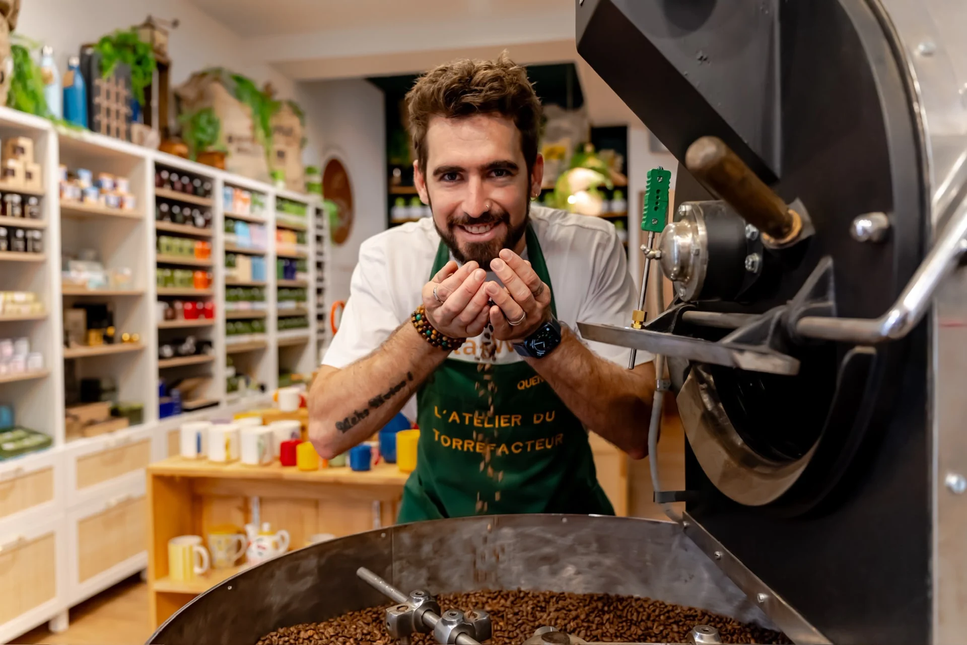 Torréfacteur de L'Atelier du Torréfacteur laissant couler des grains de café fraîchement torréfiés dans sa boutique à Saint-Raphaël